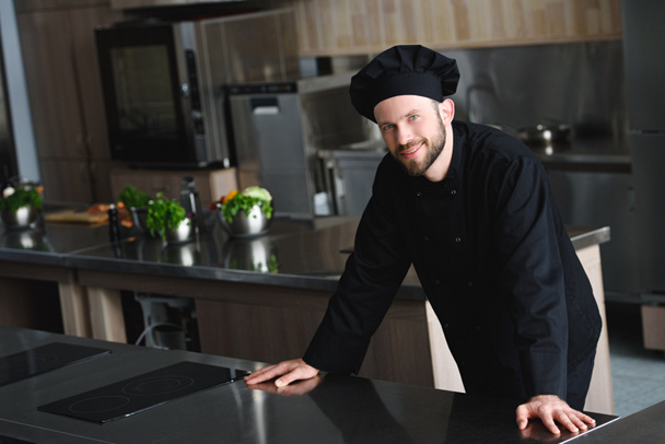 handsome chef looking at camera at restaurant kitchen - Photo, Image