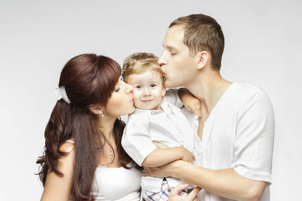 Familie Kiss, moeder vader kussende kind, ouders en kind op witte achtergrond - Foto, afbeelding