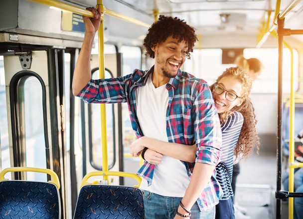 молодий щасливий чоловік і жінка обіймаються в автобусі
 - Фото, зображення