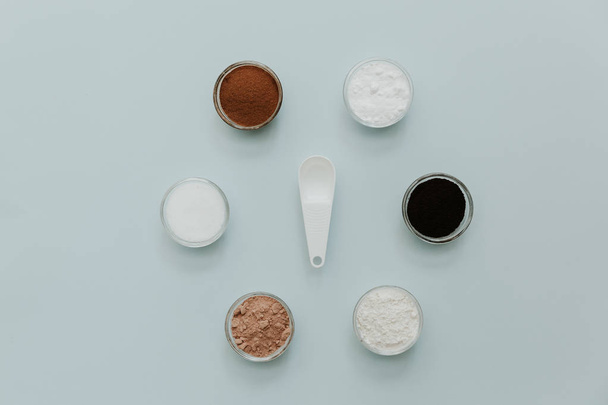 Baking soda, powder, cocoa, sugar, flour, yeast on cup for baking on pastel background. Minimal Flat lay - Fotoğraf, Görsel