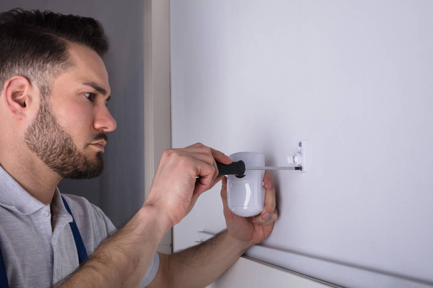 Close-up Of A Young Male Electrician Installing Security System Door Sensor On Wall - Zdjęcie, obraz