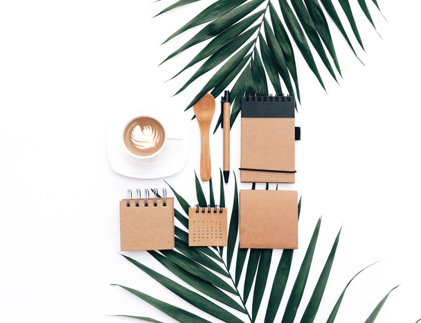 Minimal Office desk table with stationery set, supplies and palm leaves. Top view with copy space, creative flat lay. - 写真・画像