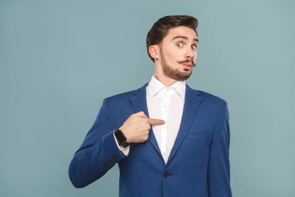 surprised businessman looking at camera and pointing finger at himself on light blue background, concept of richly and success business people  - Φωτογραφία, εικόνα