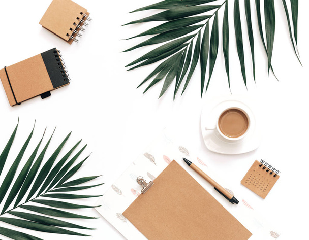 Minimal Office desk table with stationery set, supplies and palm leaves. Top view with copy space, creative flat lay. - Фото, изображение