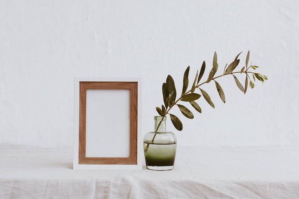 Mock up with olive branch in vase over linen tablecloth. Minimal eco concept - Fotoğraf, Görsel