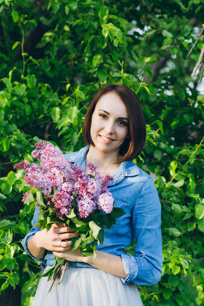 Girl posing with a bouquet of lilac - Фото, зображення