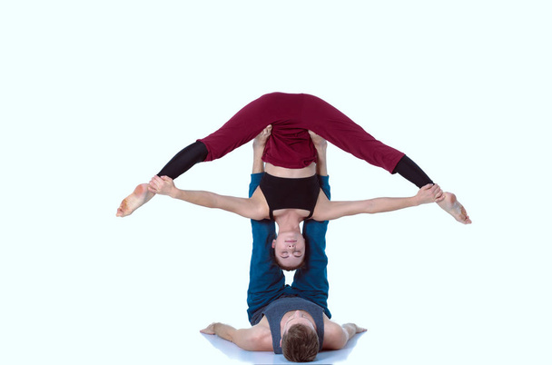 Young athletic couple practicing acroyoga. Balancing in pair - Fotó, kép