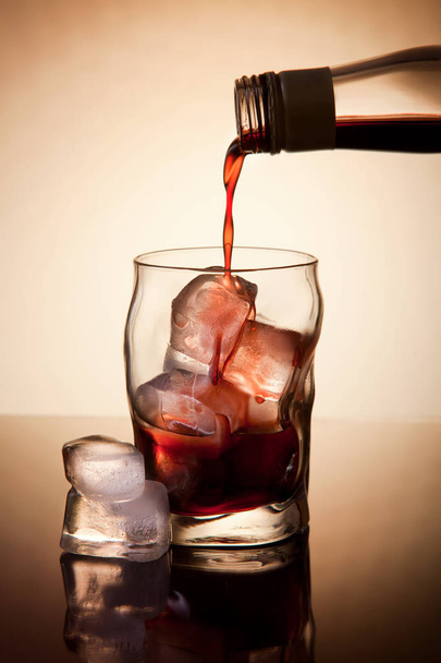 Drank drinken op de rotsen in transparant glas - Foto, afbeelding