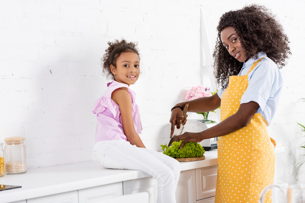 afrikai amerikai férfi és lánya vágás saláta a konyha - Fotó, kép