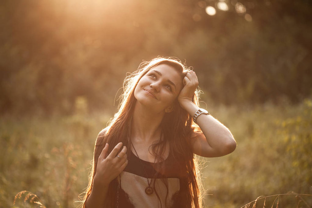 Beautiful carefree girl on field on sunset - Photo, image