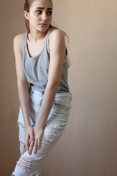 cool girl in jeans posing against  wall - Фото, зображення