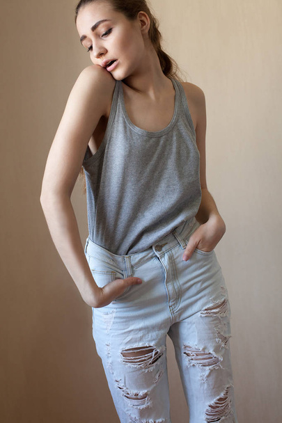cool girl in jeans posing against  wall - Φωτογραφία, εικόνα