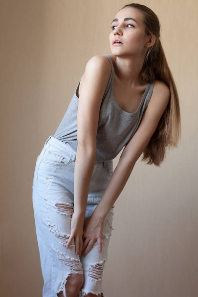 cool girl in jeans posing against  wall - 写真・画像