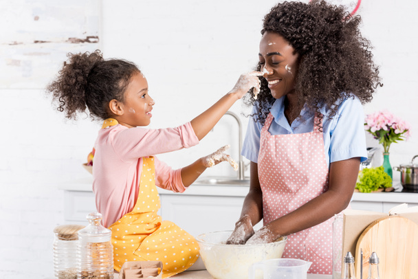 afro-américaine mère et fille s'amuser tout en faisant de la pâte sur la cuisine
 - Photo, image