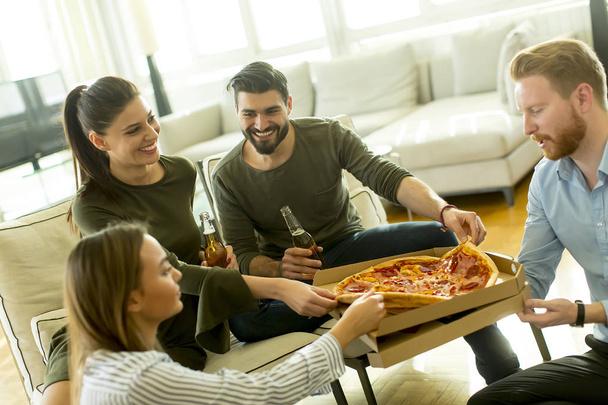 Ομάδα νέων ανθρώπων για το κόμμα πίτσα στο δωμάτιο - Φωτογραφία, εικόνα