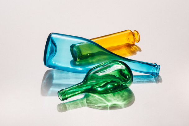 close up view of empty colorful bottles on white background - Foto, afbeelding