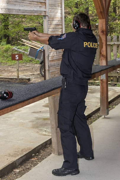 Γυρίσματα αστυνομικοί πυροβολούν από πυροβόλο όπλο στο στόχο - Φωτογραφία, εικόνα