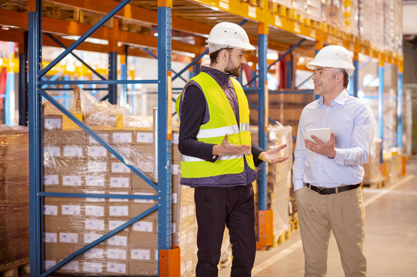 Nice young man talking to the logistics manager - 写真・画像