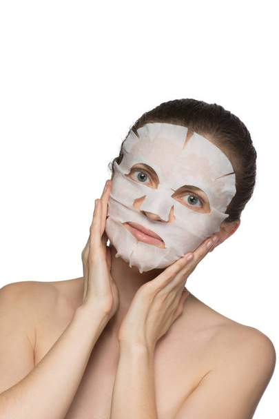 Gyönyörű fiatal nő az alkalmazása a kozmetikai maszk az arcon egy - Fotó, kép