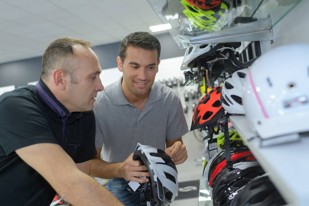 client choosing helmet in motorcycle store - Photo, image