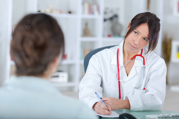 female doctor listening to her patientin office - Foto, immagini