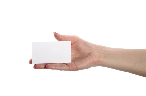 Close-up of an empty business card in a woman's hand isolated on white - Fotó, kép
