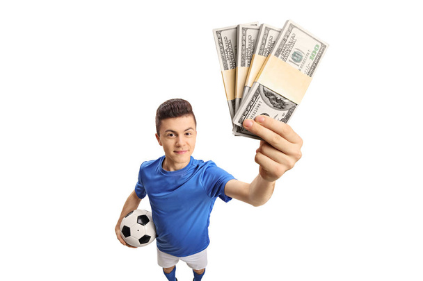Teenage soccer player with bundles of money isolated on white background - Photo, Image