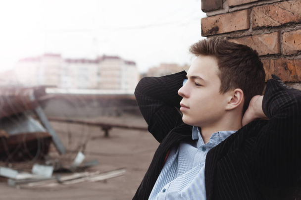 Pensive підліток сидить на даху будинку
 - Фото, зображення