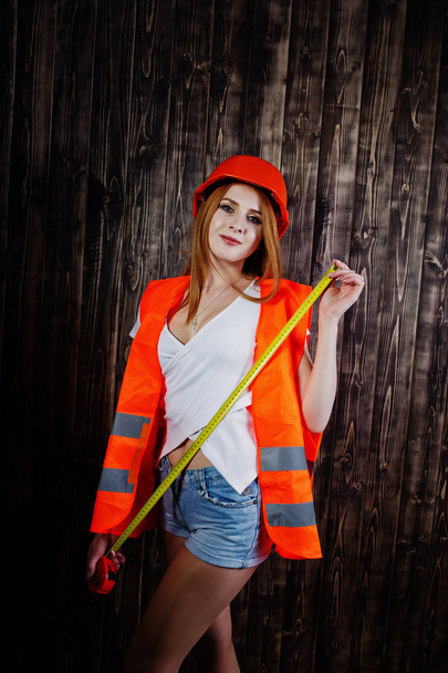 Engineer woman in orange protect helmet and building jacket agai - Фото, изображение