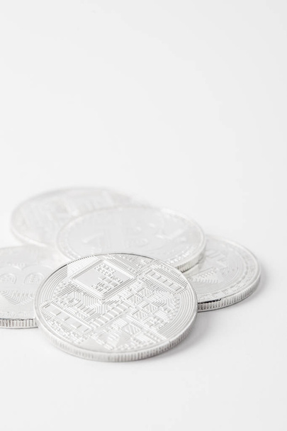 close-up shot of pile of bitcoins lying on white surface - Фото, изображение