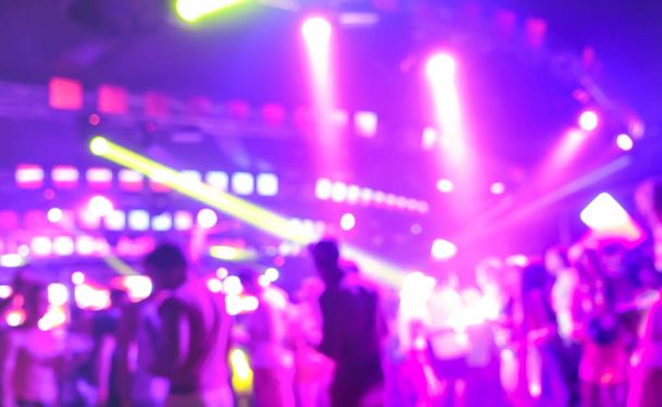 Blurred people dancing at music night festival event - Abtsract defocused image background of disco club after party with laser show - Nightlife entertainment concept - Bright marsala spotlight filter - Photo, Image