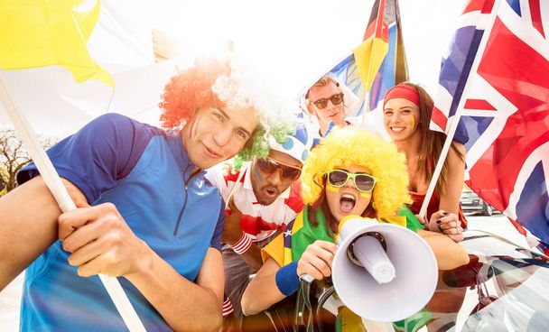 Футбольні прихильники фанів вітають друзів після матчу футбольних кубків, що висять навколо з автомобілем і прапорами - Молоді люди групують з різнокольоровими футболками, насолоджуючись концепцією спортивного чемпіонату світу
 - Фото, зображення