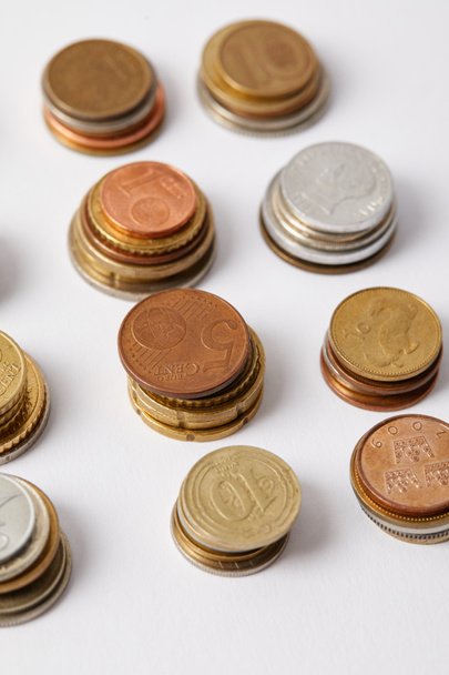 close-up shot of stacks of different coins on white - Fotoğraf, Görsel
