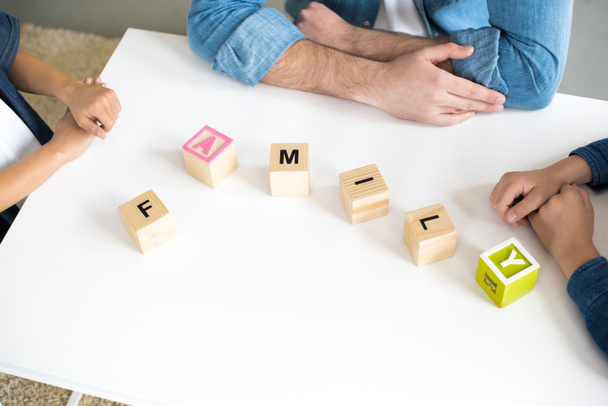 vista close-up de cubos com palavra família e mãos de pai com crianças
 - Foto, Imagem
