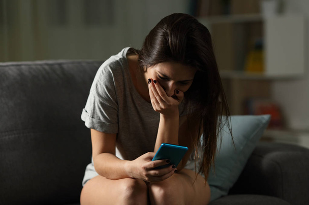 Sad teen receiving bad news online at home - Fotó, kép