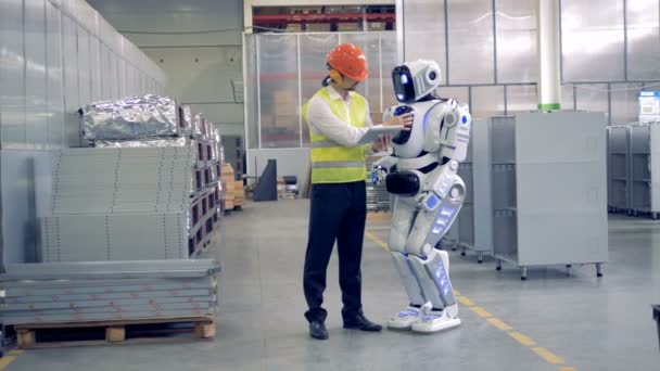 Заводський працівник показує робота, що робити на промисловому заводі
. - Кадри, відео