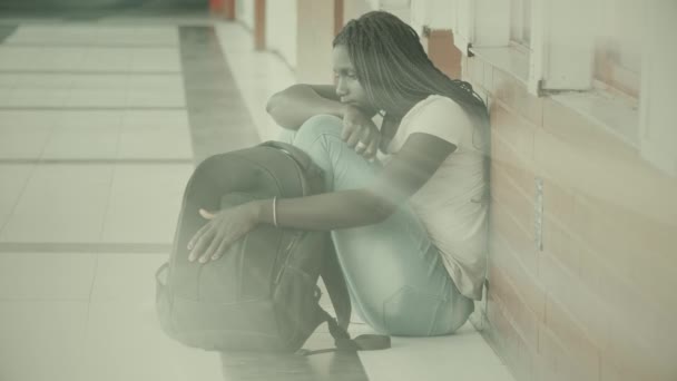 Acoso escolar. Africano americano mujer adolescente molesto sentado en la escuela pasillo
. - Metraje, vídeo