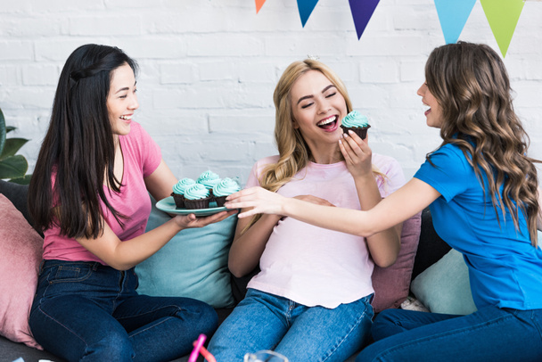 multikulturális meg és a terhes nő evés cupcakes a baba-party - Fotó, kép