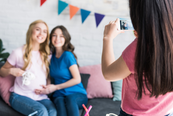 woman taking photo with smartphone of friends at baby-party - Фото, изображение
