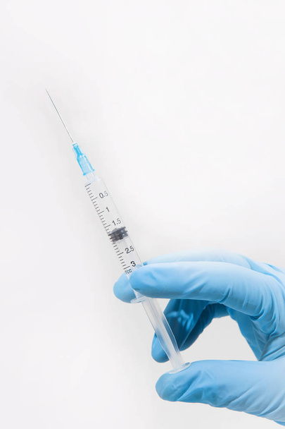 Medical gloved hand holding syringe with vitamins - Zdjęcie, obraz