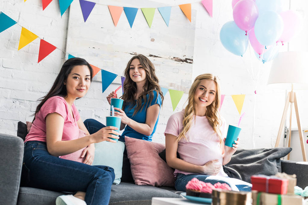 multicultural friends and pregnant woman holding drinks and looking at camera at baby-party - Photo, Image