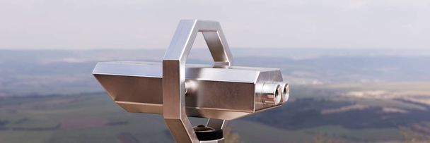 Silver Coin Operated binocular viewer with landscape in the background - Photo, Image
