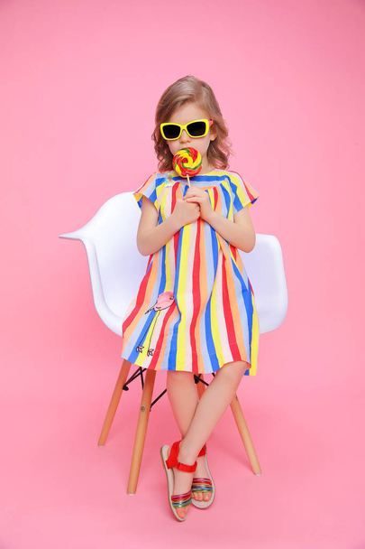 Cute girl in sunglasses with lollipop - Foto, afbeelding