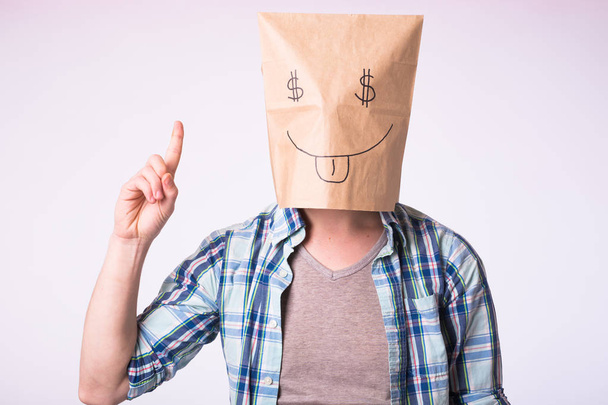 Человек с картонной коробкой на голове с изображением символа доллара вместо глаз
. - Фото, изображение