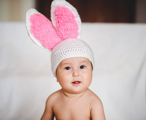 Ritratto di bambino asiatico in cappello con orecchie di coniglio su sfondo bianco
 - Foto, immagini
