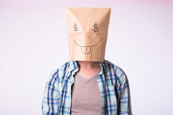 Homem com caixa de papelão na cabeça com imagem de símbolo de dólar em vez de olhos
. - Foto, Imagem