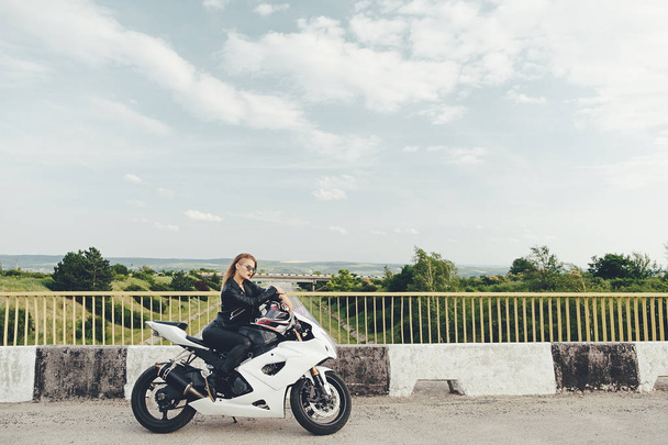Hermosa mujer conduciendo una moto en una carretera
 - Foto, imagen