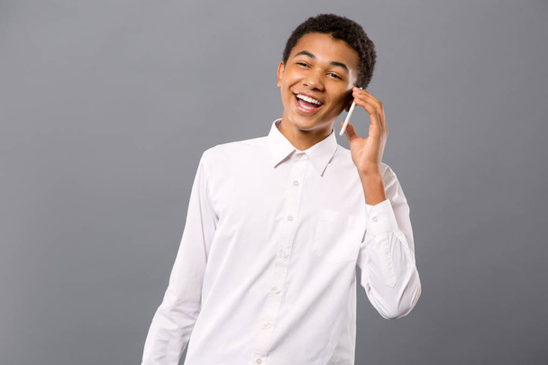 Cheerful teenage boy talking on the phone - Фото, изображение