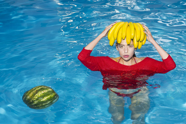Girl holding watermelon and banana in the blue pool, instagram style. Tropical fruit diet. Summer holiday idyllic. - Fotoğraf, Görsel
