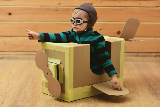 Air mail delivery, aircraft construction. Dream, career, adventure, education. Kid, pilot school, innovation. Little boy child play in cardboard plane, childhood. Pilot travel, airdrome, imagination. - Foto, afbeelding